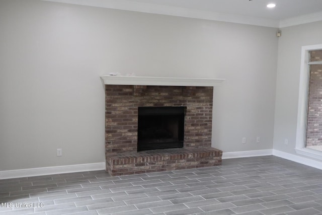 unfurnished living room featuring baseboards, a brick fireplace, crown molding, and recessed lighting