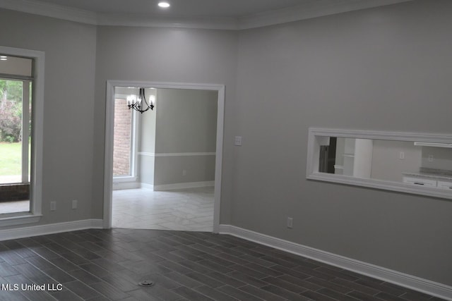 spare room with a chandelier, recessed lighting, baseboards, and crown molding