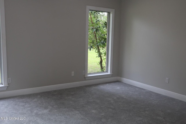 empty room with carpet floors, healthy amount of natural light, and baseboards
