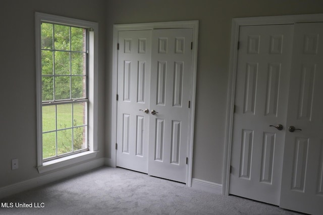 unfurnished bedroom featuring carpet, a closet, and baseboards