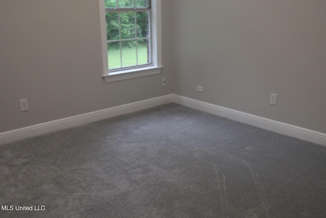 carpeted spare room featuring baseboards