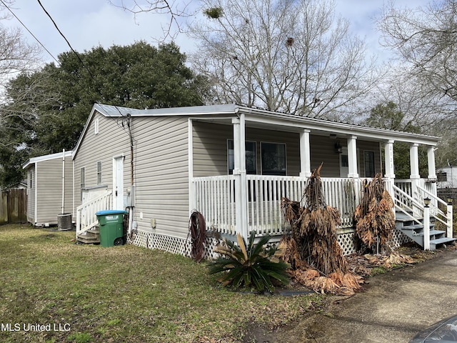 view of front of house featuring covered porch, central AC, and a front lawn