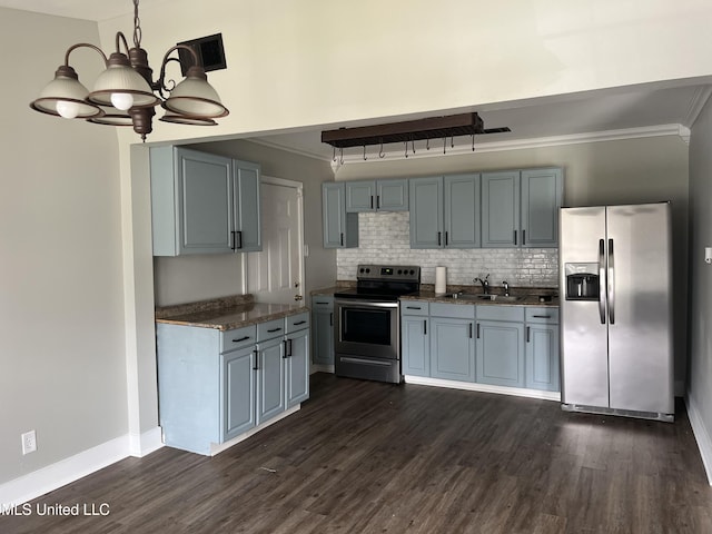 kitchen with dark countertops, appliances with stainless steel finishes, ornamental molding, dark wood-style flooring, and a sink