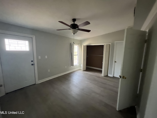 entryway featuring vaulted ceiling, plenty of natural light, dark wood finished floors, and baseboards