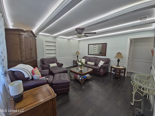 living area featuring a decorative wall, a ceiling fan, a wainscoted wall, and dark wood finished floors
