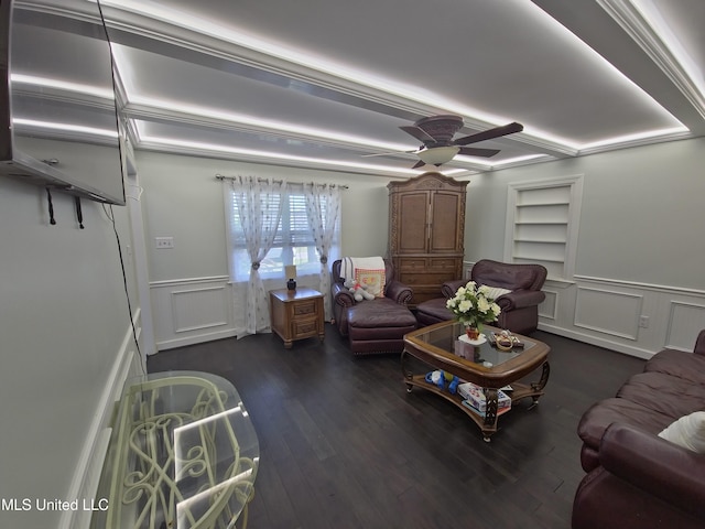 living room featuring a wainscoted wall, a decorative wall, ceiling fan, wood finished floors, and built in features