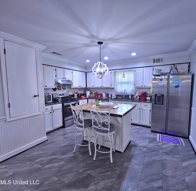 kitchen with stainless steel appliances, under cabinet range hood, a sink, butcher block counters, and white cabinets