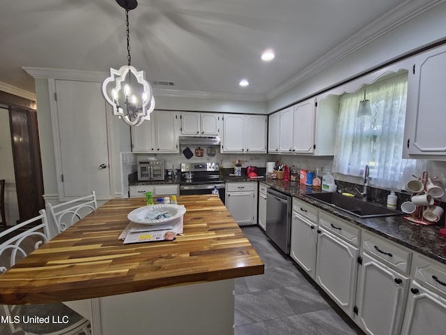 kitchen featuring crown molding, a sink, stainless steel appliances, wood counters, and an inviting chandelier