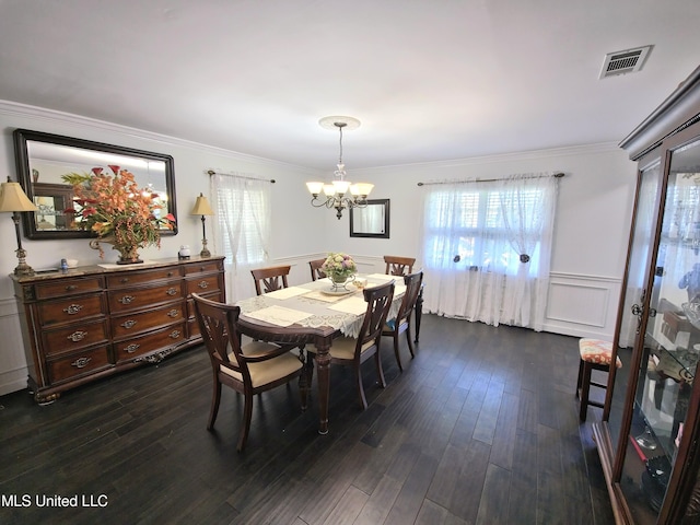 dining space with visible vents, a chandelier, crown molding, dark wood-type flooring, and wainscoting