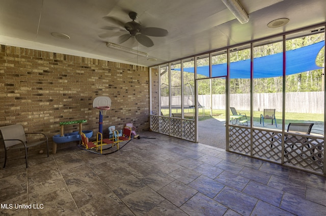 unfurnished sunroom featuring ceiling fan