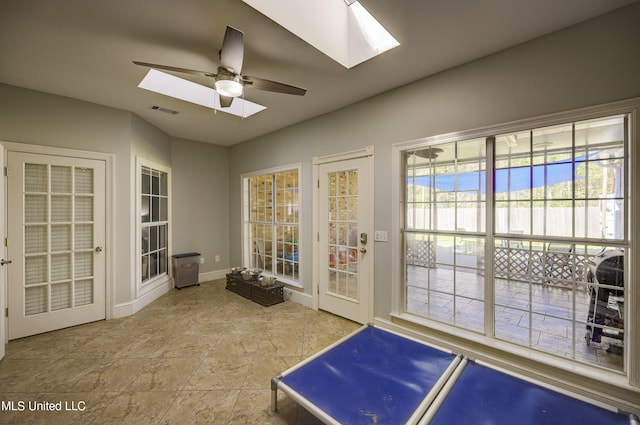 doorway featuring ceiling fan and a skylight