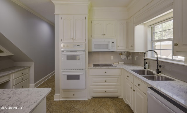 kitchen with white cabinets, tasteful backsplash, light tile patterned floors, sink, and white appliances