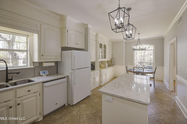 kitchen featuring a center island, sink, a wealth of natural light, and white appliances