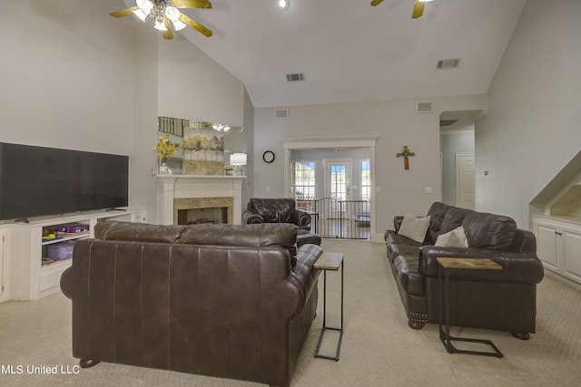 carpeted living room with ceiling fan and high vaulted ceiling