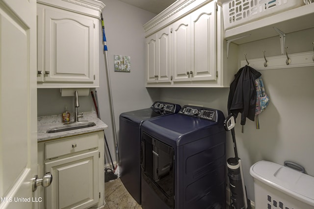 clothes washing area with cabinets, sink, and separate washer and dryer