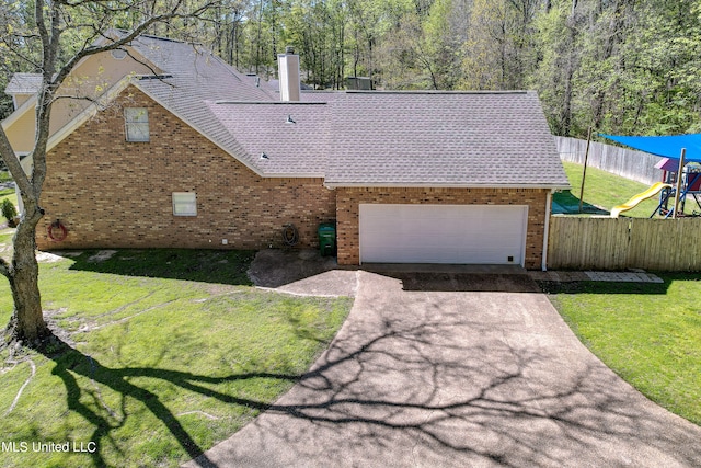 view of front of property featuring a front yard, a garage, and a playground