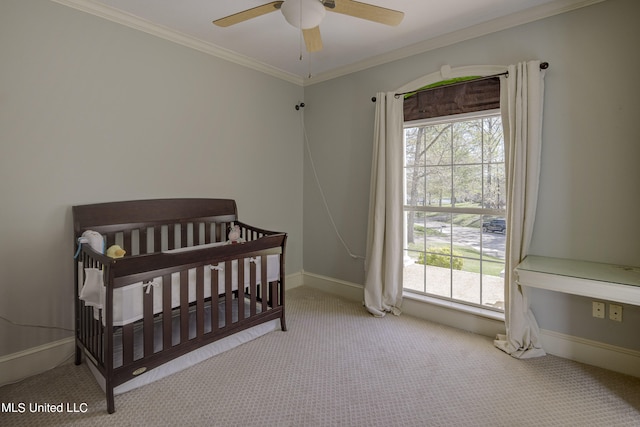 carpeted bedroom with ceiling fan, crown molding, multiple windows, and a nursery area