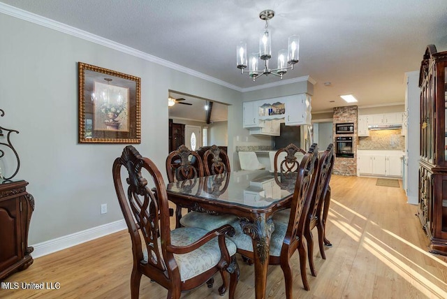 dining space with light wood-style floors, baseboards, ornamental molding, and ceiling fan with notable chandelier