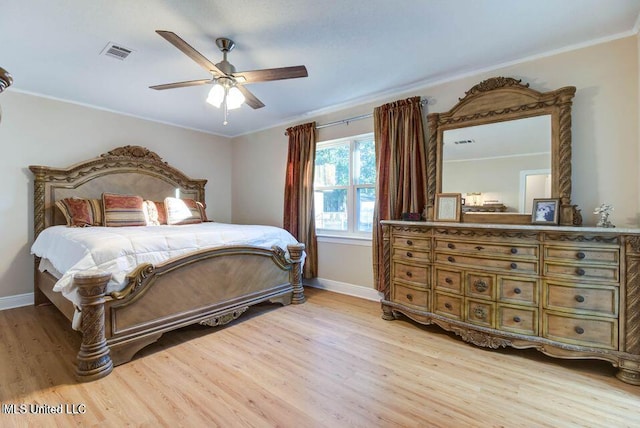 bedroom with ornamental molding, light wood-type flooring, visible vents, and baseboards