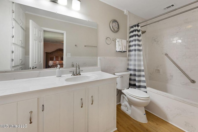 full bath with visible vents, toilet, wood finished floors, vanity, and tile walls