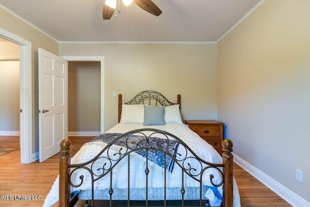 bedroom with ornamental molding, wood finished floors, and baseboards