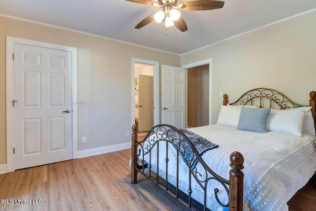 bedroom with ornamental molding, a ceiling fan, baseboards, and wood finished floors