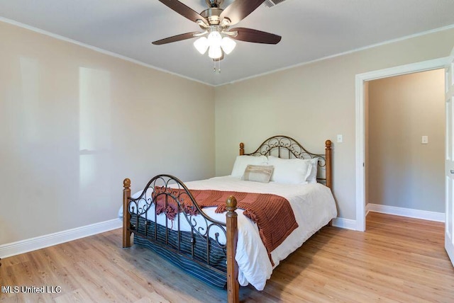 bedroom featuring light wood-style floors, baseboards, ornamental molding, and ceiling fan