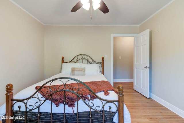 bedroom featuring crown molding, ceiling fan, light wood-style flooring, and baseboards