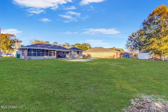 rear view of house featuring a yard, an attached carport, and a sunroom