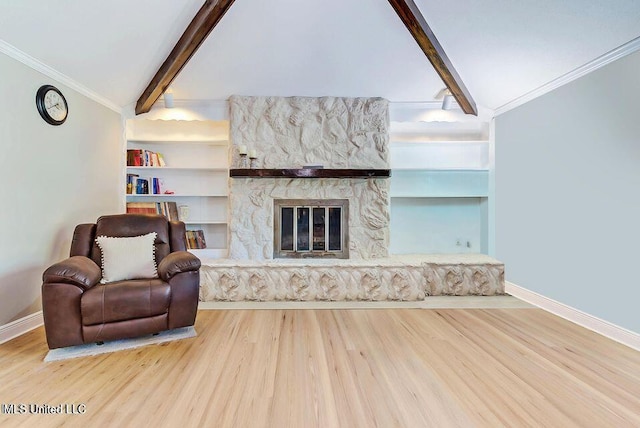 living area with baseboards, a stone fireplace, lofted ceiling with beams, and wood finished floors