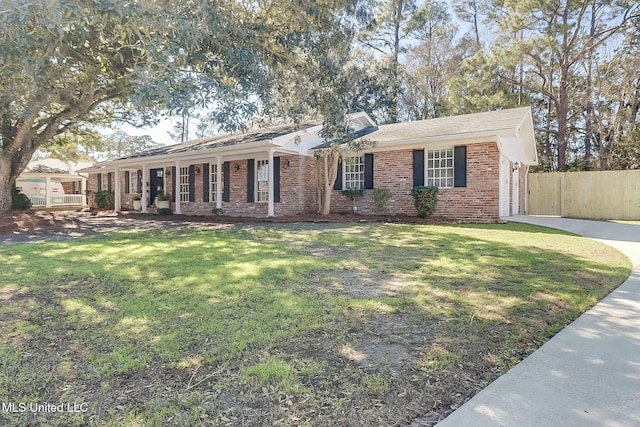 ranch-style home with a front yard, fence, concrete driveway, and brick siding