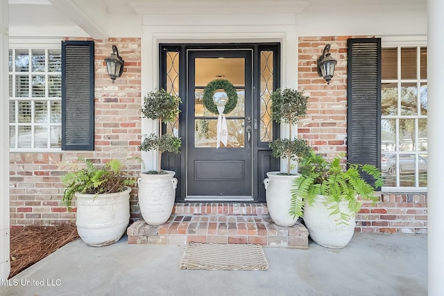 entrance to property featuring brick siding