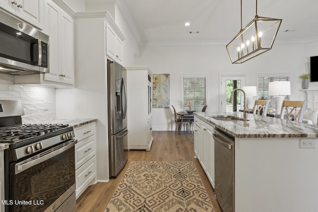 254 Buttonwood Ln, Canton, MS 39046 - kitchen with appliances with stainless steel finishes, white cabinets, light stone counters, decorative backsplash, and a kitchen island with sink