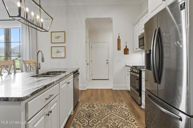 254 Buttonwood Ln, Canton, MS 39046 - kitchen with stainless steel appliances, white cabinets, light stone counters, dark wood-style flooring, and ornamental molding