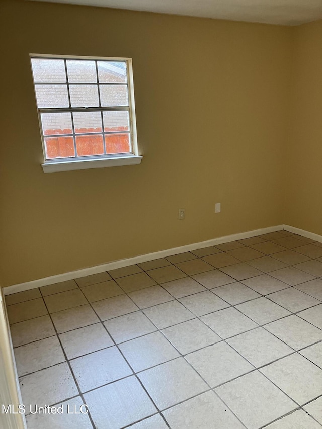 unfurnished room featuring light tile patterned floors and baseboards