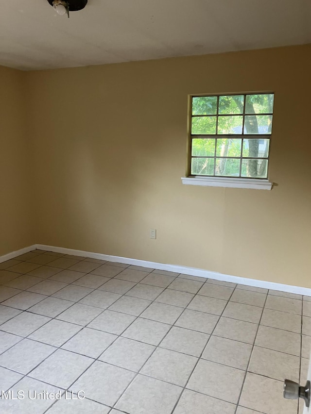 unfurnished room featuring light tile patterned flooring and baseboards