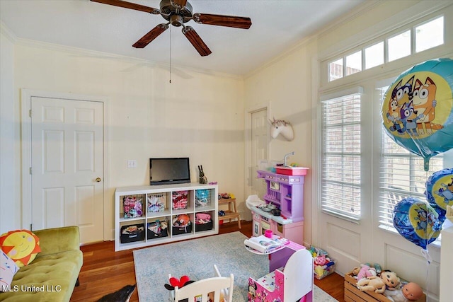 rec room with ornamental molding, wood finished floors, and a ceiling fan