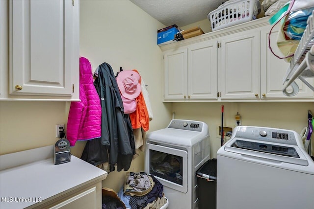 laundry area featuring washing machine and clothes dryer and cabinet space