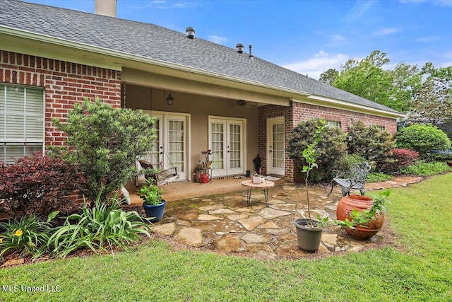 rear view of property featuring french doors, brick siding, roof with shingles, and a patio