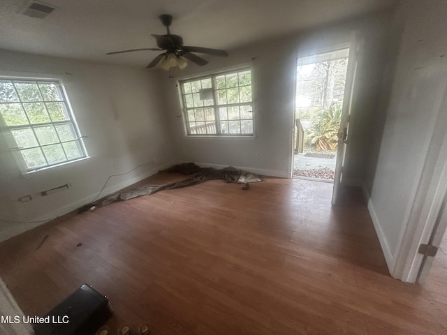 unfurnished room featuring ceiling fan, plenty of natural light, and wood-type flooring