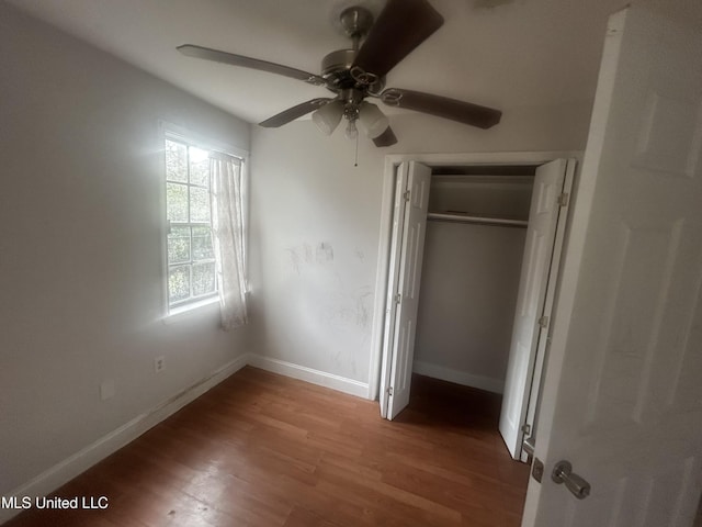 unfurnished bedroom featuring ceiling fan, wood-type flooring, and a closet