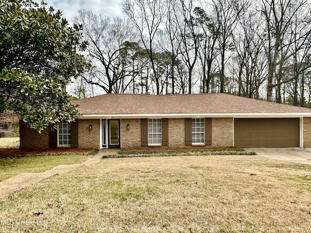 ranch-style house with brick siding, roof with shingles, concrete driveway, a garage, and a front lawn