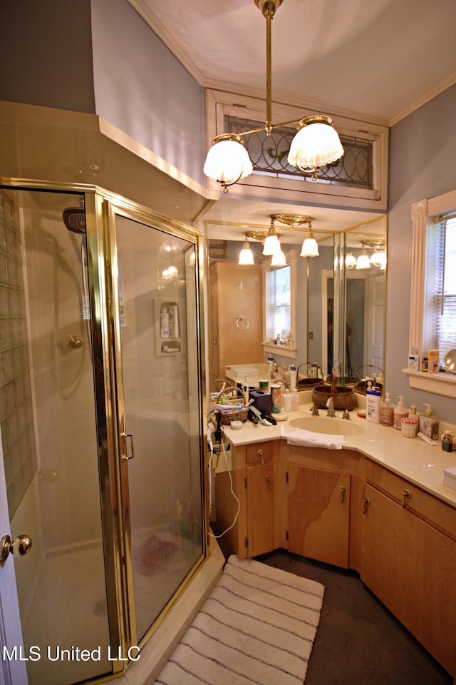 bathroom with ornamental molding, vanity, and a shower with shower door