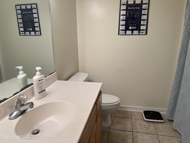 bathroom with tile patterned flooring, toilet, vanity, and baseboards