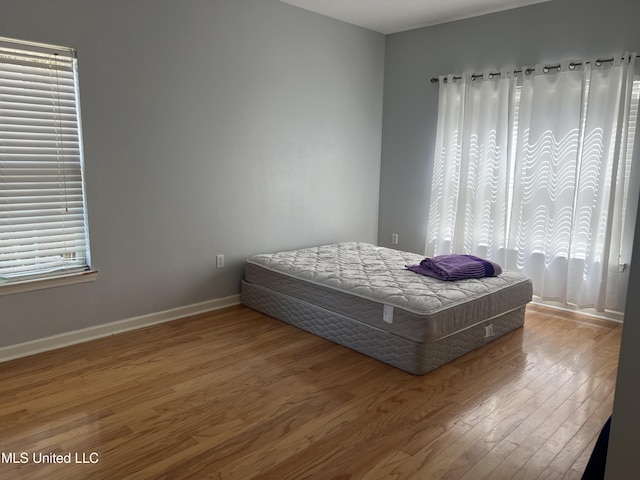 bedroom featuring baseboards and wood finished floors