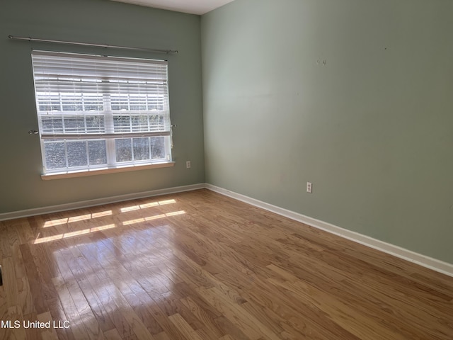 empty room featuring baseboards and wood finished floors