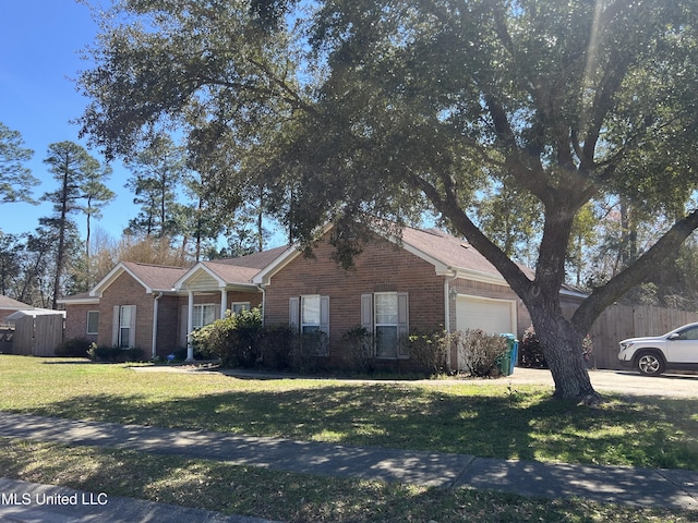 ranch-style home with brick siding, an attached garage, a front yard, and fence