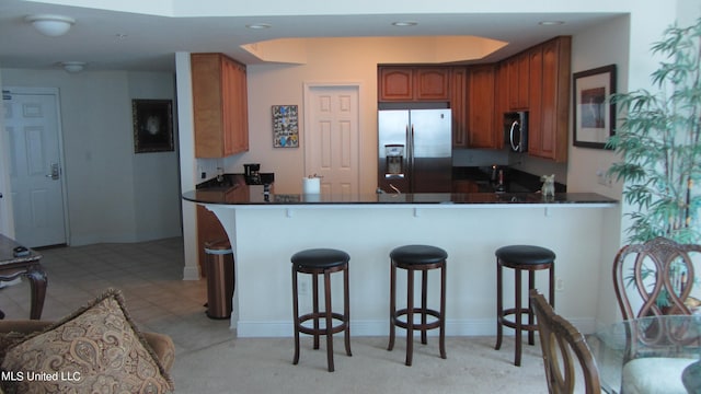 kitchen featuring appliances with stainless steel finishes, kitchen peninsula, and a kitchen breakfast bar