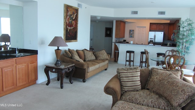 living room featuring sink and light carpet