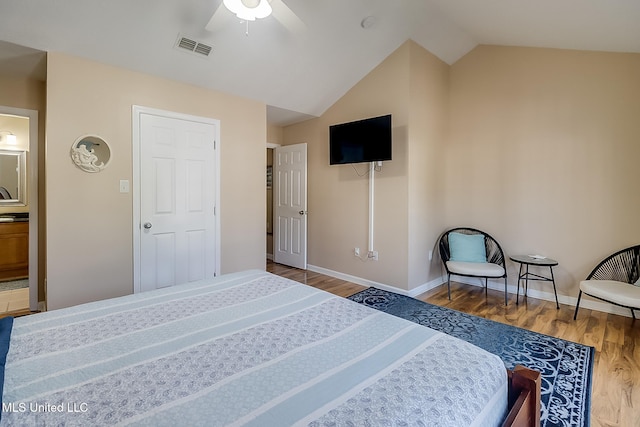 bedroom featuring connected bathroom, ceiling fan, wood-type flooring, and lofted ceiling